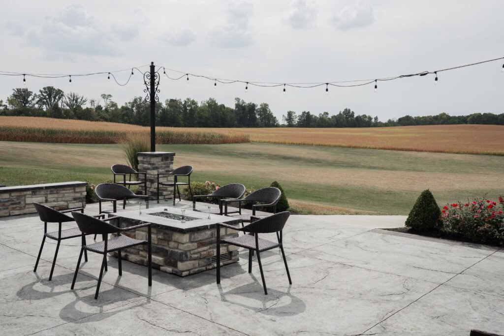 Charming outdoor patio with seating and countryside field view, perfect for relaxation.